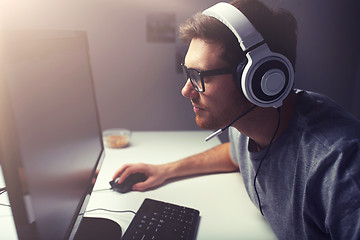 Image showing man in headset playing computer video game at home