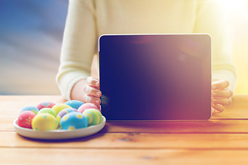 Image showing close up of woman with tablet pc and easter eggs