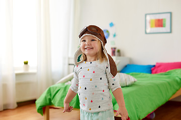 Image showing happy little girl in pilot hat playing at home