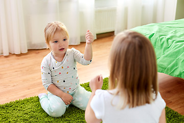 Image showing girls playing rock-paper-scissors game at home