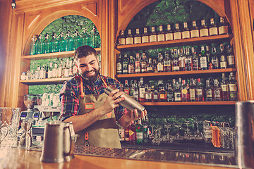 Image showing Barman making an alcoholic cocktail at the bar counter on the bar background