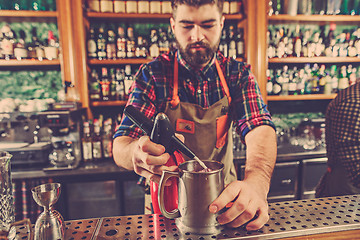 Image showing Barman making an alcoholic cocktail at the bar counter on the bar background