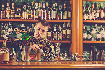 Image showing Barman making an alcoholic cocktail at the bar counter on the bar background