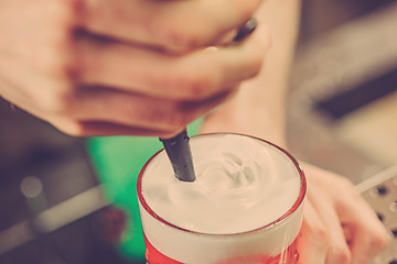 Image showing Barman making an alcoholic cocktail at the bar counter on the bar background