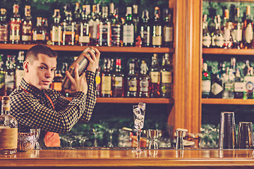 Image showing Barman making an alcoholic cocktail at the bar counter on the bar background