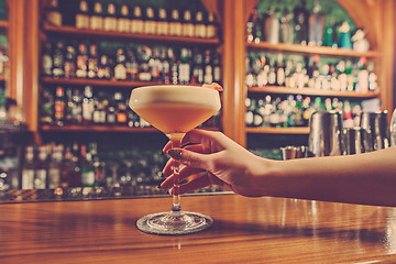 Image showing The girl is holding in his hand a glass of alcoholic beverage