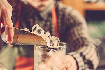 Image showing Barman making an alcoholic cocktail at the bar counter on the bar background