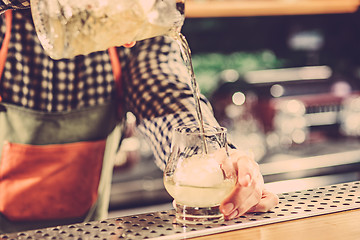 Image showing Barman making an alcoholic cocktail at the bar counter on the bar background