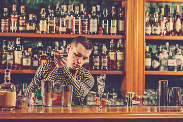 Image showing Barman making an alcoholic cocktail at the bar counter on the bar background