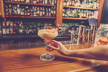 Image showing The girl is holding in his hand a glass of alcoholic beverage