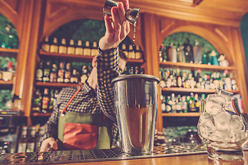 Image showing Barman making an alcoholic cocktail at the bar counter on the bar background