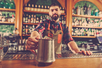 Image showing Barman making an alcoholic cocktail at the bar counter on the bar background