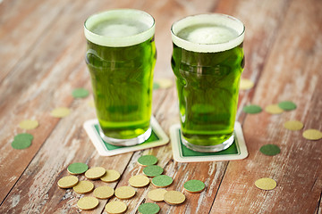 Image showing glasses of green beer and gold coins on table
