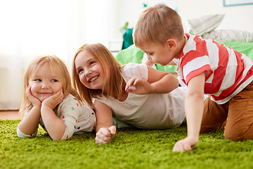 Image showing happy little kids lying on floor or carpet