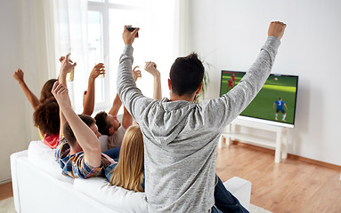 Image showing friends watching soccer on tv and celebrating goal