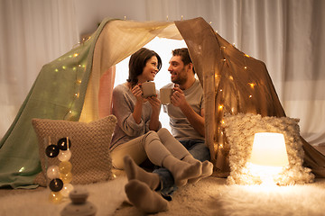 Image showing couple drinking coffee or tea in kids tent at home