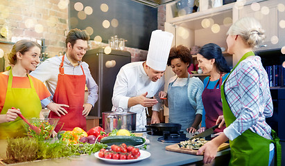 Image showing happy friends and chef cook cooking in kitchen