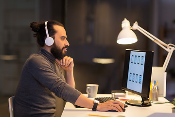 Image showing creative man with headphones working at office