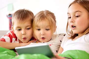 Image showing little kids with tablet pc in bed at home