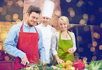 Image showing happy couple and male chef cook cooking in kitchen