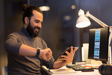 Image showing man with smartwatch and tablet pc at night office