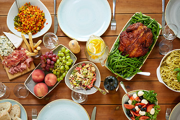 Image showing various food on served wooden table