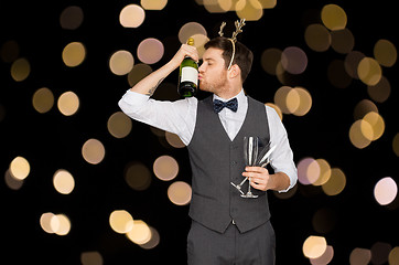 Image showing man kissing bottle of champagne at christmas party