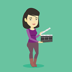 Image showing Smiling woman holding an open clapperboard.