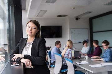 Image showing Elegant Woman Using Mobile Phone by window in office building