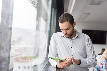 Image showing Businessman Using Tablet In Office Building by window