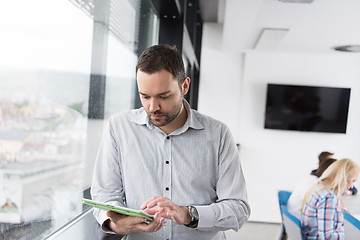 Image showing Businessman Using Tablet In Office Building by window