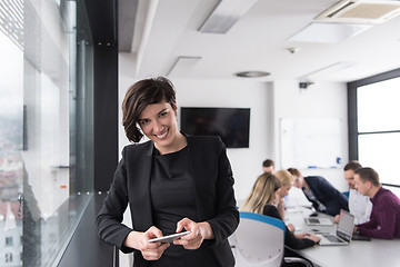 Image showing Elegant Woman Using Mobile Phone by window in office building