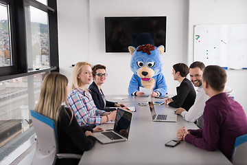 Image showing boss dresed as bear having fun with business people in trendy of