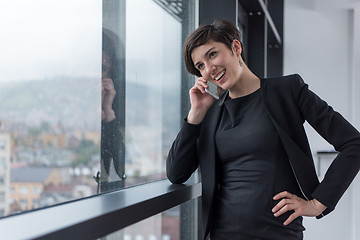 Image showing Elegant Woman Using Mobile Phone by window in office building