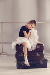 Image showing The little girl as balerina dancer sitting at studio