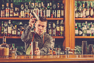 Image showing Barman making an alcoholic cocktail at the bar counter on the bar background