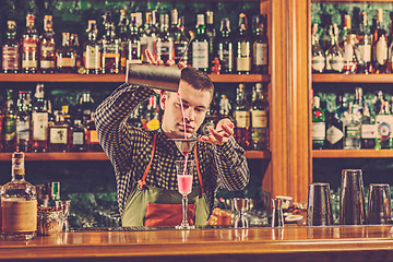 Image showing Barman making an alcoholic cocktail at the bar counter on the bar background