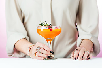 Image showing The rose exotic cocktails and fruits and female hand