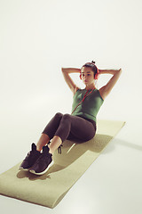 Image showing Front view of a young woman stretching body in gymnastics class.