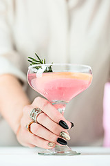 Image showing The rose exotic cocktails and fruits and female hand