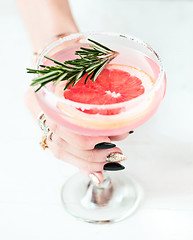 Image showing The rose exotic cocktails and fruits and female hand