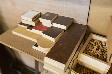 Image showing wood dowel pins and board samples at workshop