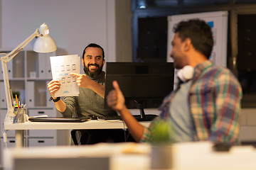 Image showing creative man showing papers to colleague at office