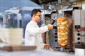 Image showing chef slicing doner meat from spit at kebab shop