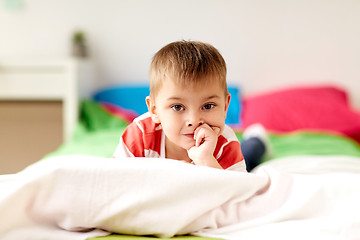 Image showing portrait of little boy lying on bed at home