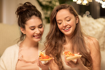 Image showing happy female friends eating pizza at home