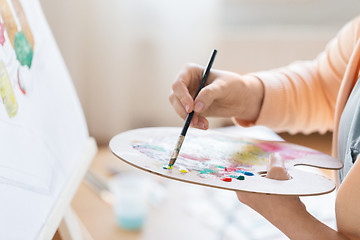 Image showing artist with palette painting at art studio