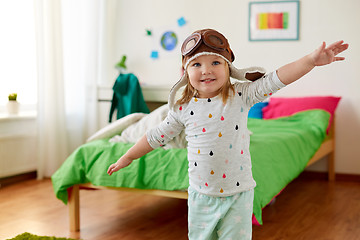 Image showing happy little girl in pilot hat playing at home