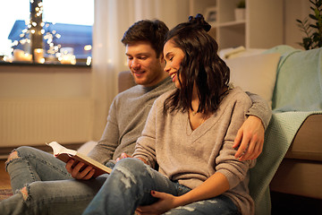 Image showing happy couple reading book at home