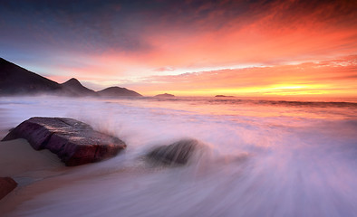 Image showing Ocean sunrise as large waves wash onto the beach